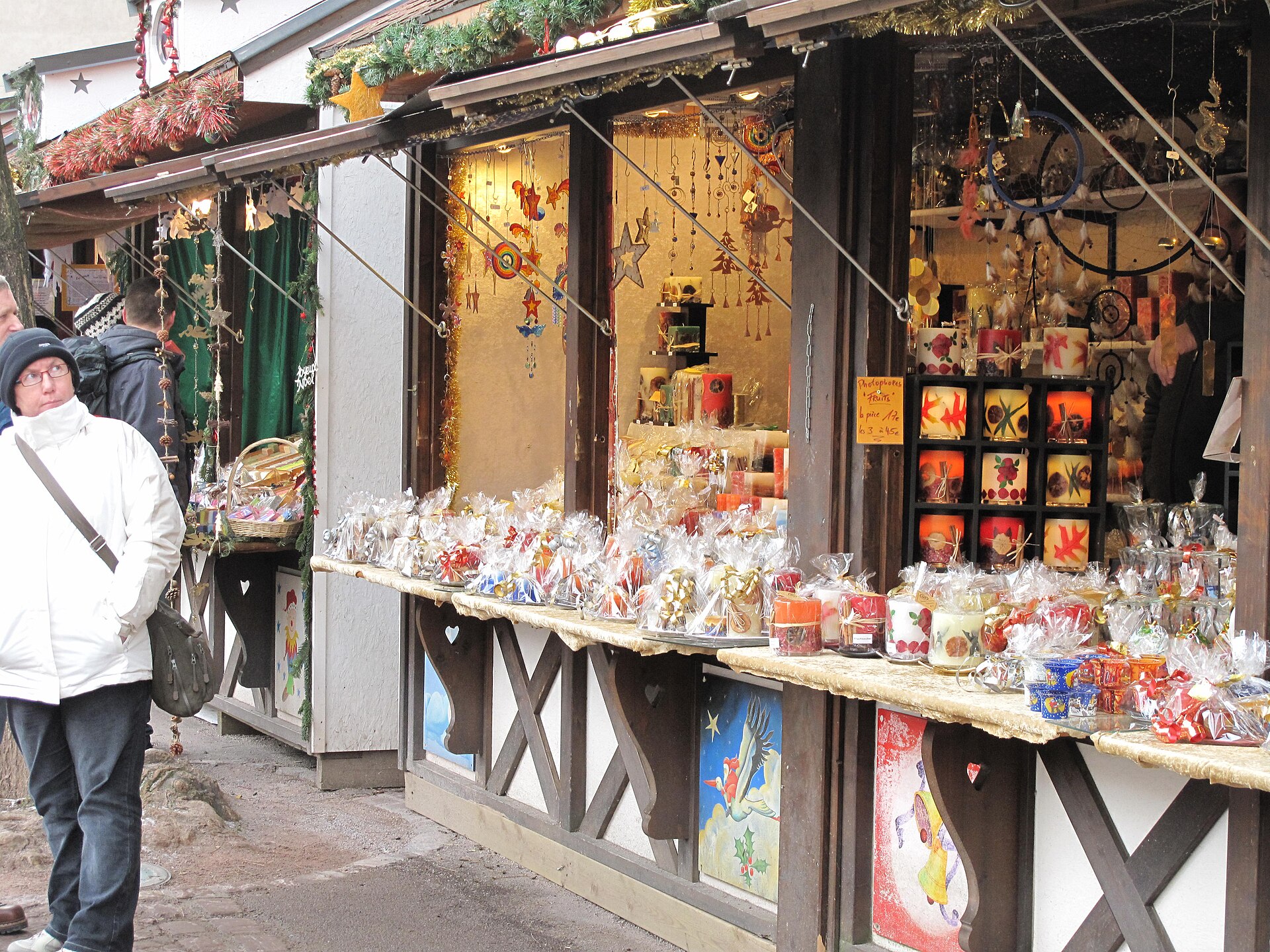 Chalets en bois d'un marché de Noël, guirlandes allumées au crépuscule